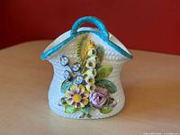 front view showing blue handle and applied multicolour flowers
