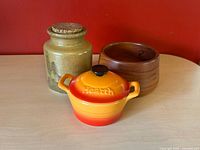 Group shot of all three items: stoneware jar, Hearth casserole with lid, wood bowl