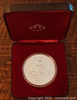 Coin in red clamshell case showing obverse design