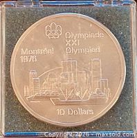 Coin in plastic holder, reverse side showing Montreal skyline and Olympic rings