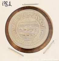 Obverse of 1982 British Columbia trade dollar in flip showing salmon design and legend