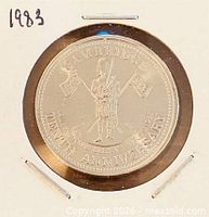 Obverse view of 1983 Cambridge trade dollar in flip