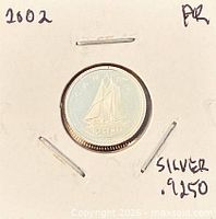 Coin in holder front showing reverse schooner design