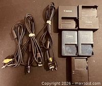 Group shot of five Canon chargers and three cables