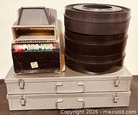 Overall lot showing both slide viewers, three carousel trays, and two metal slide cases