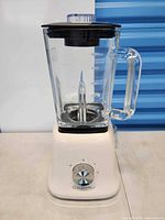 Fully assembled blender, front view showing base, jar, lid, handle and brand