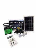 Entire solar power kit showing power station, solar panel, three LED bulbs, cables, remote, manual, box