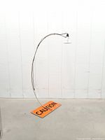 Full view of arc floor lamp on caution sign base