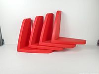 Four red L-shaped shelves stacked