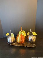 Front view of three pear containers on leaf tray