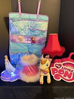 Group shot of all items showing organizer, lamp, unicorn toy, Elsa figure, dress and My Little Pony case