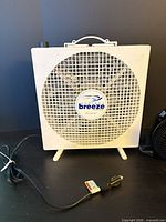 Front view of Endless Breeze white box fan with grill, handle and power cord