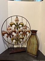 Front view of both the metal art piece and vase together