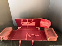 Fold-out Estée Lauder makeup case opened showing two detachable zip pouches and carry handle