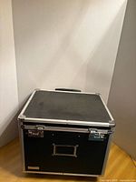 Closed chest front view showing black panels, aluminium frame, front handle and locks