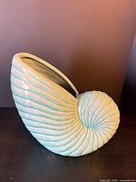 Full view of nautilus shell ceramic planter standing upright