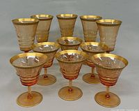 Group of 11 amber etched glasses showing two sizes
