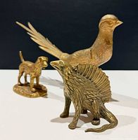 Front view of all three brass figurines displayed together