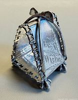 Front view showing "Best Wishes" engraving, wishbone arch, feet, star-cut border