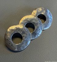 Front view of silver brooch showing three textured discs