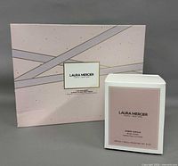 Front view of closed Body Essentials gift box beside Ambre Vanille crème box