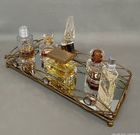 Front angled view of six perfume bottles on metal mirrored tray