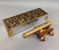 Box and cannon side by side showing relative size and materials