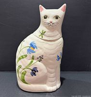 Front view of ceramic cat cookie jar showing floral design and lid