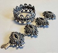 Bracelet laid flat next to wide bangle