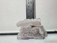 Front view of rose quartz animal figurine against ruler measuring under 4 in tall