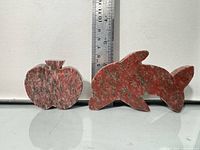 Front view of both jasper figurines beside ruler indicating sizes