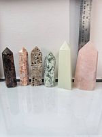 Six crystal towers lined up beside ruler