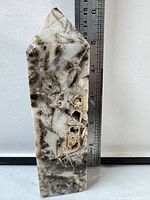 Front view of quartz and sphalerite obelisk next to ruler