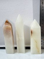 Front view of three jade obelisk towers with ruler showing height