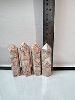 Four jasper towers standing beside ruler showing height