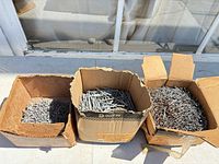 Three open boxes filled with nails
