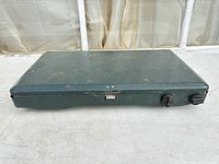 Closed Cole­man stove top view showing exterior wear