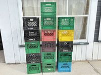 Full view of two stacked columns of assorted plastic milk crates