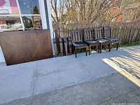 table top and four chairs lined up outdoors