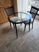Round glass table with two matching chairs