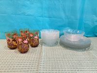 Group shot showing four amber tumblers, stack of clear bowls, stack of clear plates
