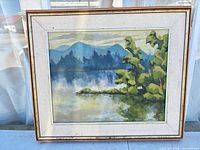 Front view of framed painting showing landscape scene and frame