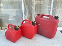 Group shot of three red jerry cans showing relative sizes and caps