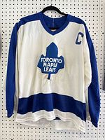 Front view of CCM Toronto Maple Leafs Clark captain jersey displayed on hanger