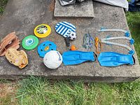Wide view of assorted sports and beach items on concrete slab