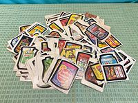 Pile of vintage Topps Wacky Packages and related stickers scattered on surface