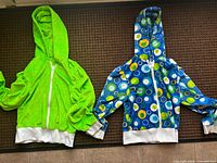 Both hoodies laid flat showing colours, zips and trim