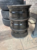 Stack of three black Ford F-150 rims with sensors visible