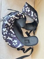 Full view of dog sling carrier showing strap, pouch, mesh lining and paw/bone print