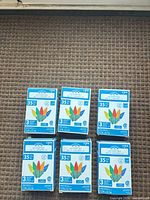 Six boxed Holiday Time C6 LED light sets arranged on carpet
